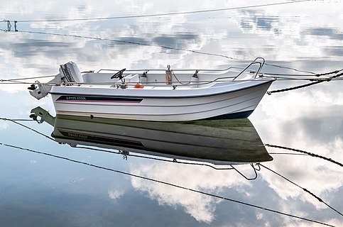 Motorboat Ryds 435DL and cloud reflections in Sämstad harbor, Lysekil Municipality, Sweden.