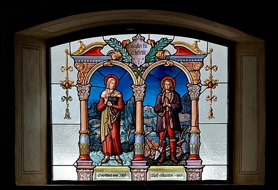 Muster für Eheleute (“modelo para casados”), vitral criado em 1885 pelo mestre de estuque Josef Rief na igreja paroquial de Nossa Senhora da Assunção em Nesselwängle, Tirol, Áustria. O vitral retrata o casal de santos, Maria Toribia e Isidoro, o Lavrador. Apesar dos séculos que se passaram, Isidoro e Maria continuam a ser fortes exemplos do significado vocacional do matrimônio, não apenas como uma instituição que atende a uma necessidade de afeto ou de continuar uma linhagem familiar, mas também como uma vocação por meio da qual as pessoas podem alcançar a santidade. (definição 3 564 × 2 446)