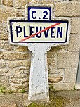 Un panneau Michelin de sortie de la commune de Pleuven dans le Finistère. Il a été retiré du service au bord de la route puis installé contre la mairie de Pleuven en tant que patrimoine et souvenir.