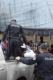 Policía Nacional de Panamá entregando bolsas de víveres a residentes de Loma Cova en Arraiján.jpg