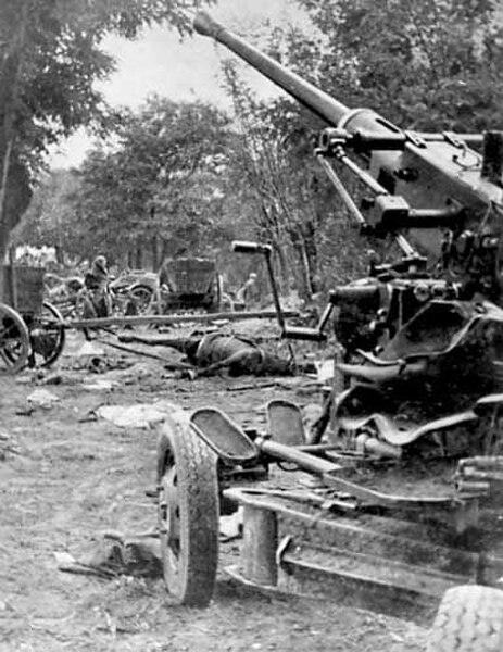 The aftermath of a bombing of a Polish column, with a Bofors 40 mm gun in the foreground
