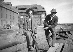 Architect Robert Reamer (left) and the construction foreman, Mr. George, at the Canyon Hotel during construction in October 1910. The second hotel, incorporated into the new hotel, is visible at left Reamer at Canyon Hotel.jpg