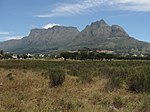 The Rondebosch Common is situated almost opposite the Rustenburg estate and fully two kilometres east of the Liesbeek River. In 1805, during the preparations for defending the Cape against a British attack, General Janssens’s Batavian force was camped on a large area which included what is now the Rondebosch Common. Dysentery broke out amongst the troops and General Janssen’s seventeen-year-old son, a recruit, was one of those who succumbed to the epidemic. The force was then moved to higher terrain at Wynberg. After the occupation of the Cape the land at Rondebosch continued to be used as a camping place for British troops for a number of years, up to the time of Lord Charles Somerset. This is why the street that borders on the Western side of the present Common was called Camp Ground Road. At the request of Bishop Gray, the first Anglican Bishop in South Africa, Governor Cathcart in 1855 granted the right to graze cattle on the Common to the Rector of St. Paul's Church, Rondebosch, with the proviso that the public was always to enjoy access to the area. At the same time two adjoining pieces of land on the Common were given to the Wesleyan and Mohammedan communities for use as graveyards. Pine trees were planted round them, and this is the origin of the cluster of pine trees we see on the Common today. In 1870 it was transferred to the Municipality