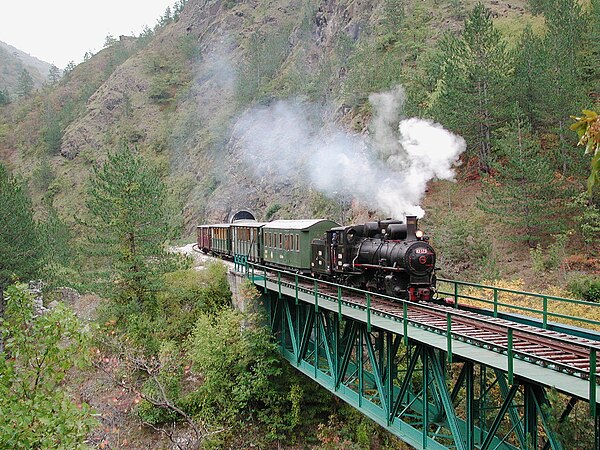 Train crossing a deck truss bridge on Serbia's Šargan Eight line