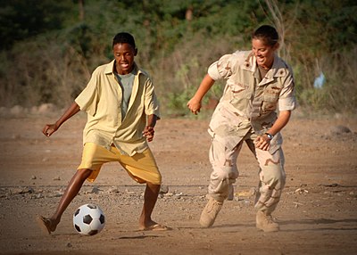 A US Navy lieutenant plays football with a Djiboutian boy at an orphanage in Djibouti City, Djibouti.