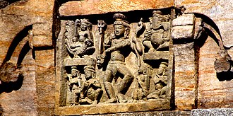7th-century Nataraja relief on Temple 1 of Jageshwar Temples; Ganesha in upper right corner, Skanda-Kartikeya on his peacock in upper left, Parvati in lower left and a musician playing vadya in lower right. The Dancing Shiva....rare depictions of Ancient India.JPG