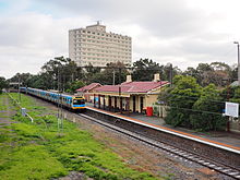 An old station viewed from further away with an apartment building in the background