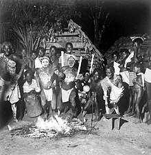 Dutch Royal Tropical Institute, Objectnumber 10019264, Portrait after a Winti-dance in a Maroon village, Suriname, 1948. The dance is called Wintidansi or wentipee in the Ndyuka language. The dancers prepared their bodies with herbs and are therefore able to dance through the fire. While making music (striking the Apinti, singing and dancing) it is possible for the dancer to go into a trance. The Winti-dance is only performed on special occasions. Tropenmuseum Royal Tropical Institute Objectnumber 10019264 Portret na afloop van een Winti dans.jpg