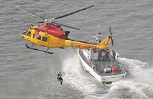 A CH-146 of the Royal Canadian Air Force 424 Squadron conducts rescue swimmer hoist training in 2012 120222-G-AY304-176 (6789453180).jpg