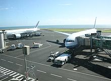 Des Boeing 777 aux couleurs d'Air France et Air Austral stationnés face à l'aérogare.