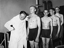 Men standing in line waiting for a medical check