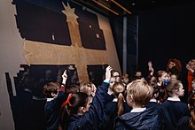 Students learn about the Eureka flag and the Eureka Stockade. Eureka Flag with Students.jpg