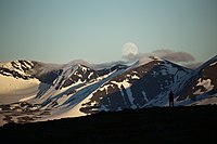 WLE: Silhuett av en fotograf framför fullmåne över bergen i Abisko nationalpark. Kortet är taget från berget Nuolja.