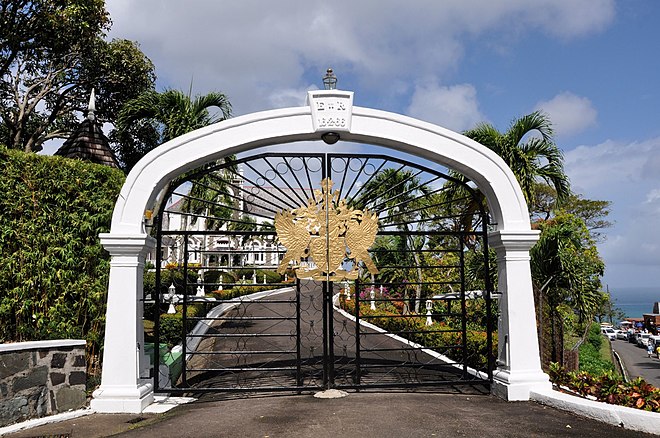 The arch above the gates of Government House, Castries, featuring an inscription marking Queen Elizabeth II's first ever visit to Saint Lucia on 16 February 1966