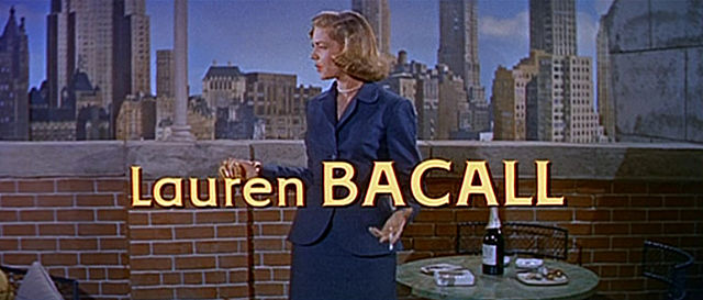 Lauren Bacall with a city skyline in the background with her name at the bottom of the image