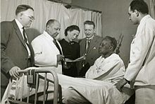 Myra Logan with colleagues at patient bedside, Harlem Hospital, New York, N.Y. From left to right: Lyndon M. Hill, Louis T. Wright, Myra Logan, Aaron Prigot, unidentified African-American woman patient, and unidentified hospital employee. Louis-T-Wright-colleagues-Harlem-Hospital-NY.jpg