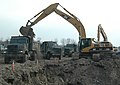 Dump trucks collecting clay to be used for flood protection