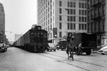 New York Central Lines' "three-power" DEs-3 locomotive operating past the R.C. Williams warehouse at 259 Tenth Avenue, Chelsea, Manhattan, New York in 1934. NYCentral DEs-3.png