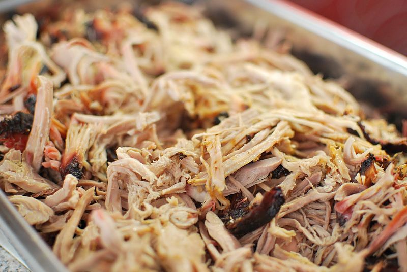 A catering tray of pulled pork barbecue. Pork barbecue meat is smoked and then shredded into then fibers, like those in the picture.