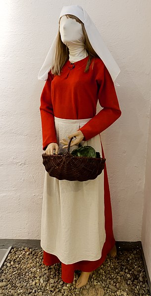 File:Rekonstruert kvinnedrakt fra middelalderen ("kvinne med legende urter fra slaget på Stiklestad 1030") Hodelin skaut kjortel draktspenne forkle Medieval women's clothing Bergenhus festningsmuseum Fortress Military Museum Bergen A.jpg