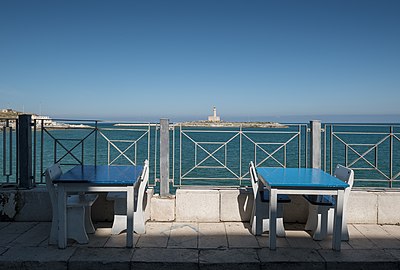 Restaurant terrace with Vieste lighthouse in the background, Via Pola, Vieste, Italy