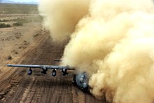 A HC-130 Hercules gets a brownout on a dirt airstrip