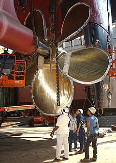 Shipyard employees reattaching the bronze propeller of USS George Washington while in dry dock