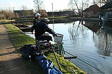 Fishermen on a canal using a fishing rod and net Urban Fishing.jpg