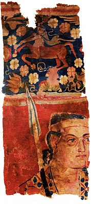 The Sampul tapestry, a woollen wall hanging from Lop County, Hotan Prefecture, Xinjiang, China, showing a possibly Greek soldier from the Greco-Bactrian kingdom (250–125 BC), with blue eyes, wielding a spear, and wearing what appears to be a diadem headband; depicted above him is a centaur, from Greek mythology, a common motif in Hellenistic art;[70] Xinjiang Region Museum.