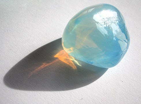 Tyndall effect in an opalite: it scatters blue light making it appear blue from the side, but orange light shines through; opal is a gel in which water is dispersed in silica crystals