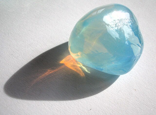 Rayleigh scattering in opalescent glass: it appears blue from the side, but orange light shines through.