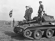 Winston Churchill stands on a Covenanter tank of 4th-7th Royal Dragoon Guards, to take the salute at an inspection of 9th Armoured Division near Newmarket, Suffolk, 16 May 1942