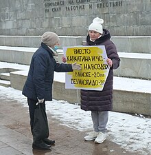 Пикетчица Елена Парий с плакатом против штрафов за неиспользование СИЗ разговаривает с прохожей Екатеринбург 24 октября 2020 года.jpg