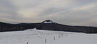 Blick vom Dorf auf den Schwarzen Hügel im Winter.  Zykovo