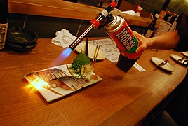 Using a blowtorch to sear raw fish