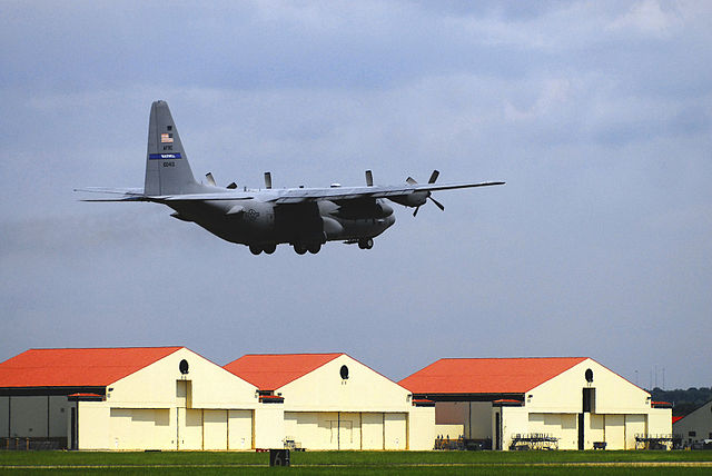 A wing C-130 Hercules takes off from Maxwell AFB with the wing's hangars in the background