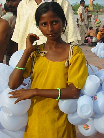 A girl selling plastic containers in Haridwar for carrying Ganges water.