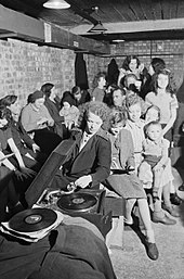 A young woman plays a gramophone in an air raid shelter in north London during 1940. A young woman plays a gramophone in an air raid shelter in north London during 1940. D1631.jpg