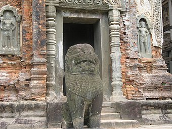 Preah Kô. Brique sur base en grès, colonnettes, linteau, figures de niches et lion en grès vert. À dr. : stuc sculpté