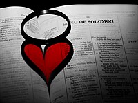 Heart shaped shadow cast by a ring on the pages of the Bible. Song of Solomon chapter 1 is shown on the right page. BookOfLove.jpg