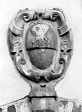 Stemma barocco in pietra della Famiglia Alfieri su Casa Scarampi. Borgo di San Michele. Si nota che la metà inferiore dell'ovale, al di sotto dell'aquila coronata, è stata scalpellata.