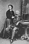 Daughter Jenny Marx (standing) with Karl Marx (seated).jpg