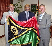 Edward Natapei (Mitte) mit der Flagge Vanuatus