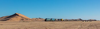 Trem de carga puxado por duas locomotivas a diesel-elétrica Classe sul-africana 33-400 na rota Swakopmund–Walvis Bay, Namíbia. Entre 1968 e 1970, as Ferrovias da África do Sul colocaram em serviço 115 locomotivas diesel–elétrica Classe 33-400 General Electric U20C. Muitas delas foram transferidas para a TransNamib, uma empresa ferroviária estatal da Namíbia, após a independência do Sudoeste Africano em 21 de março de 1990. (definição 7 478 × 2 196)