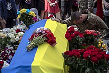 Image of a coffin covered in an Ukraineian flag