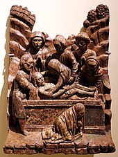 Une sculpture sur bois représentant la mise au tombeau d'un corps par un groupe d'hommes pendant un groupe pleure