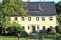 Granittürstock und Flurfenster mit schmiedeeisernen Gittern eines ehemaligen Umgebindehauses