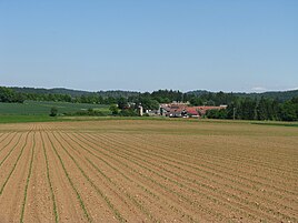 View from the southwest.  Behind the village is the Jura motorway service station.