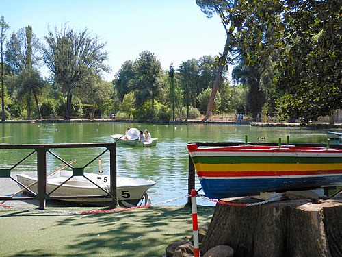 Barchetta a righe colorate e le barche del Laghetto di Villa Borghese a Roma