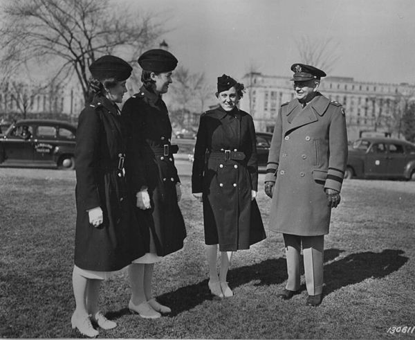 Quartermaster General Maj Gen Gregory discusses Army nurses' clothing with Lt. Alice Montgomery, Lt. Josephine Etz, and Lt. Leophile Bouchard, of Walt